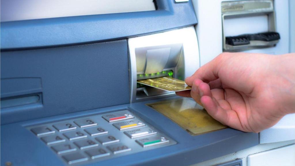Una persona sacando dinero de un banco.